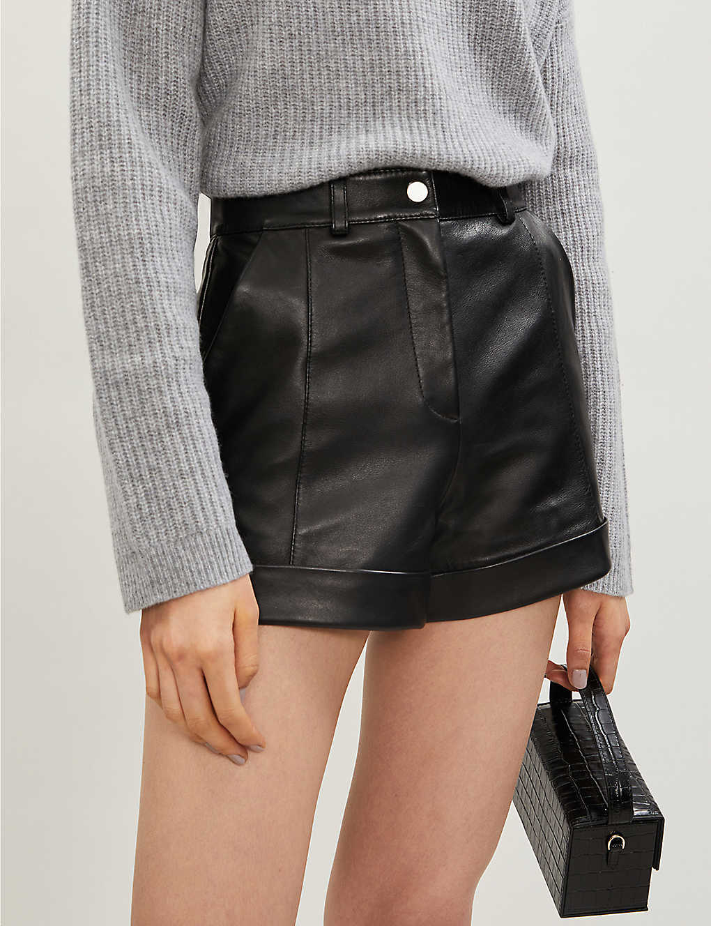 Women's black mini leather skirt with sleek front design – stylish high-waisted faux leather skirt for chic outfits.