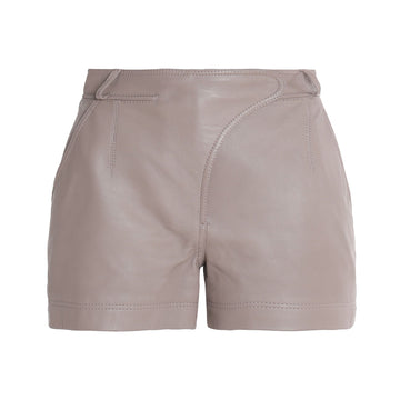 Model wearing women’s real leather taupe shorts styled with boots and a jacket for a modern chic look.