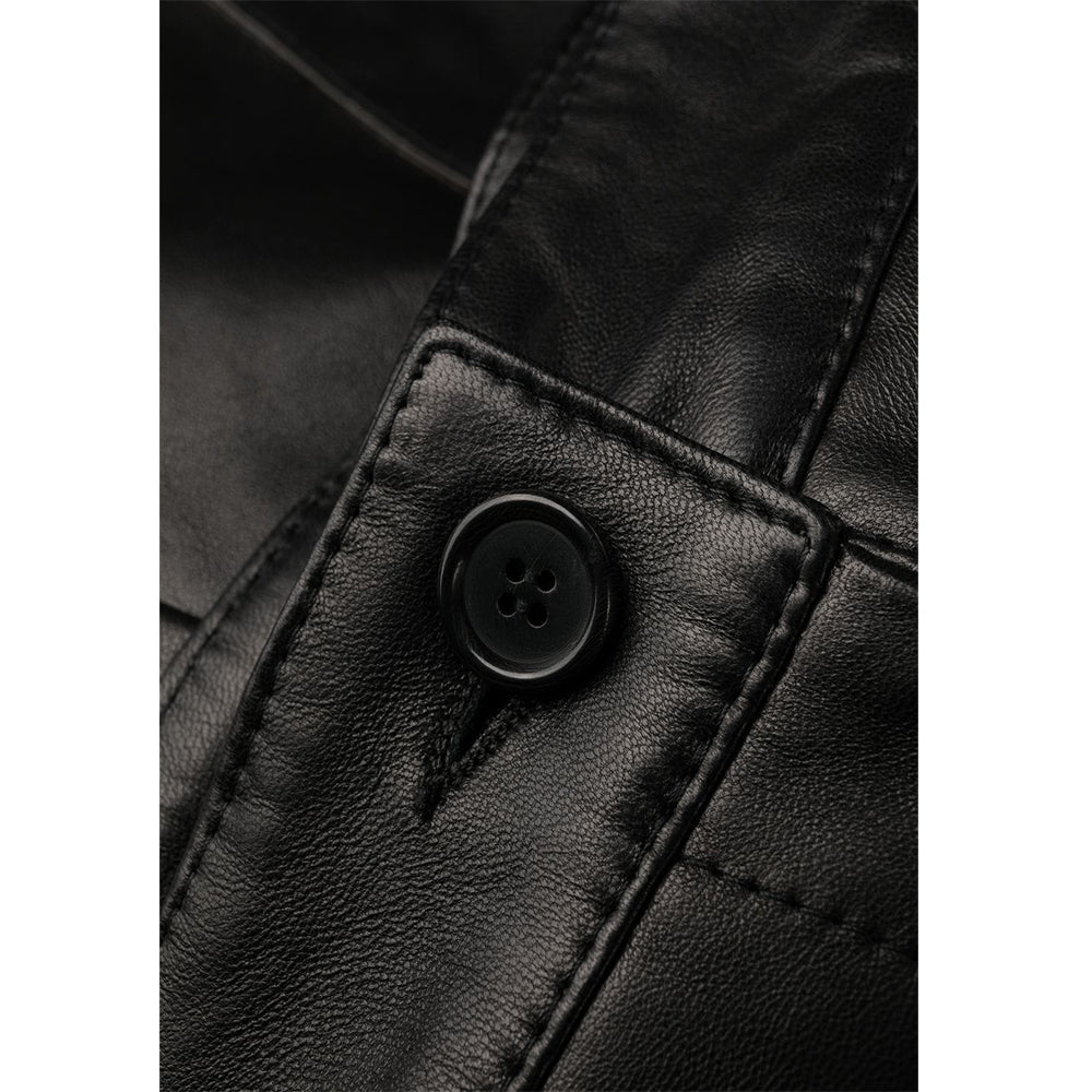 Close-up of genuine black leather texture and fine stitching on women’s casual high-waist shorts.