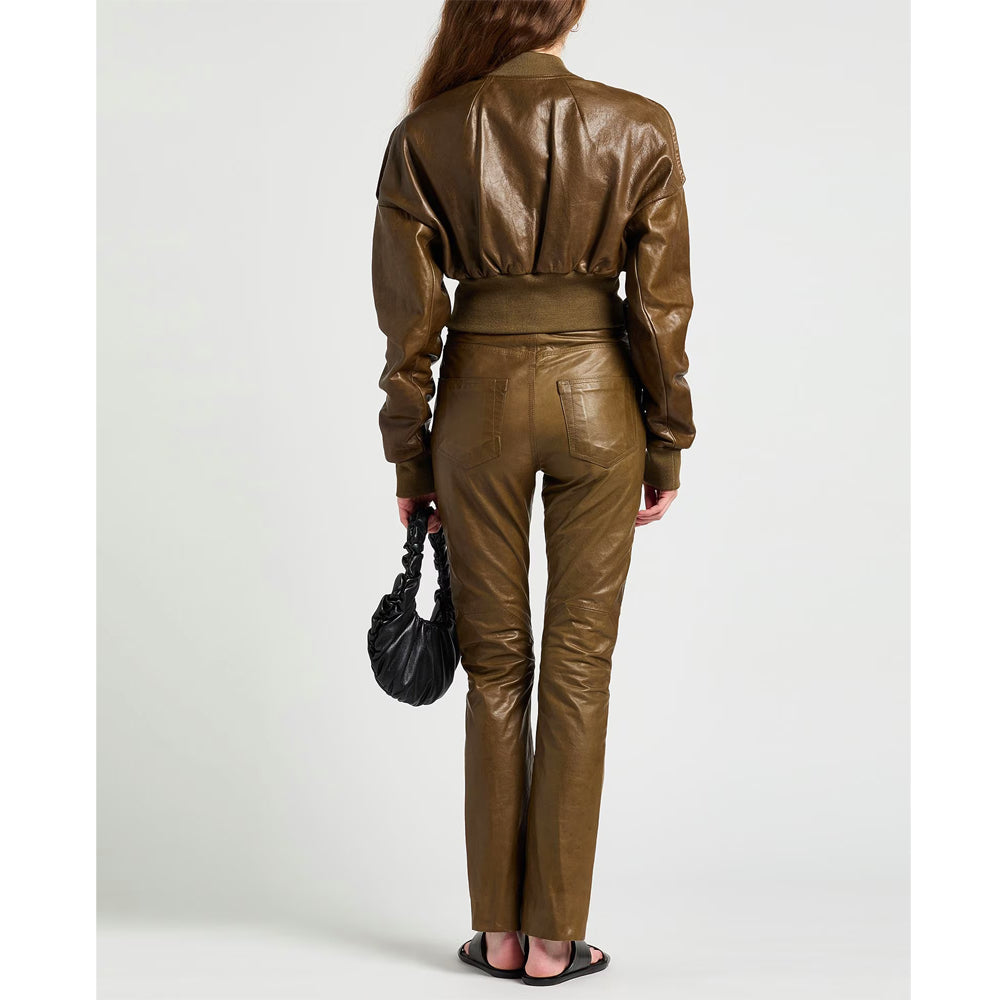 Person wearing a brown leather outfit holding a black handbag on a white background