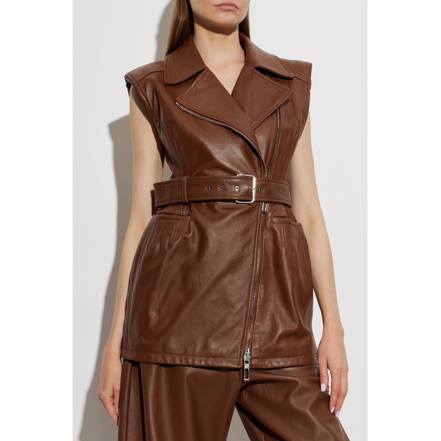 Close-up of women’s brown leather biker dress featuring wide waist belt, metal buckle, and front zipper