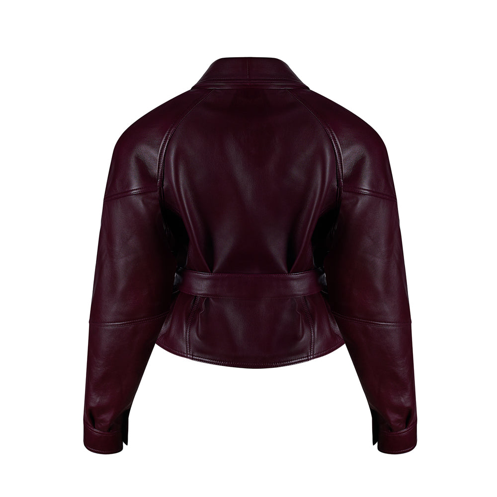 Short women’s leather jacket in burgundy featuring structured shoulders, cropped length, and adjustable belt design