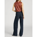 A model shown from the back wearing a brown leather sleeveless vest and dark blue wide-leg jeans against a light gray studio background.