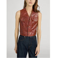 A model wearing a cropped brown leather vest with front button closures and flap pockets, paired with dark blue jeans, against a light gray studio background.