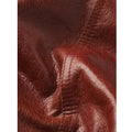 Close-up of textured brown leather with visible grain, stitching, and folds.