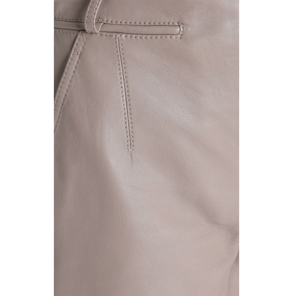 Close-up of premium taupe leather texture and designer stitching on women’s high-rise shorts.